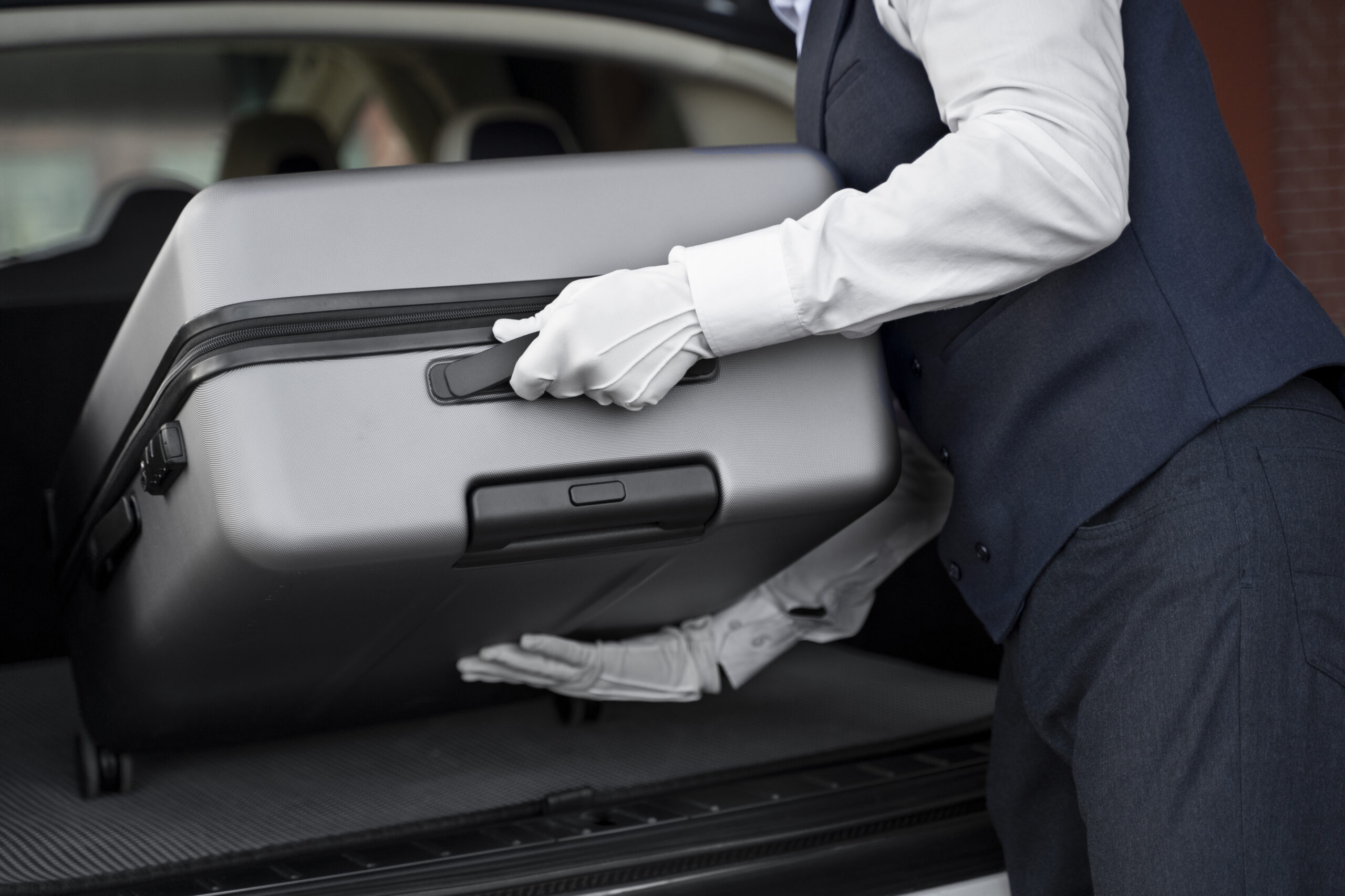 side view valet putting baggage trunk
